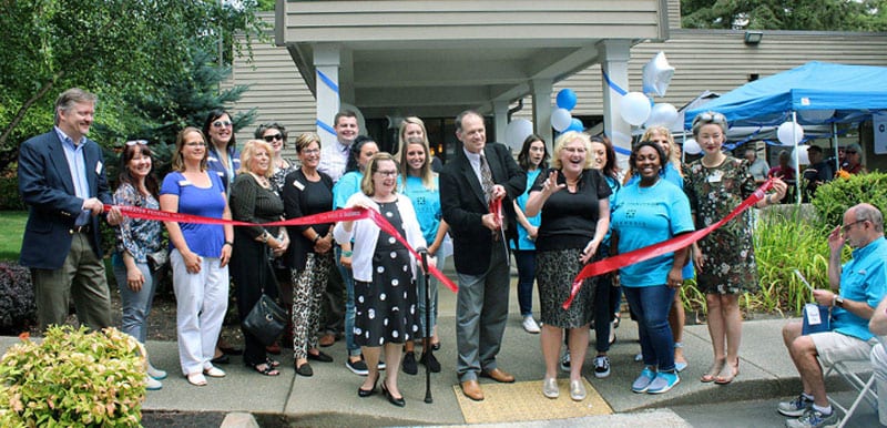 Group of people, including Dr. David Velling, in front of Genesis Spine, Joint & Regenerative Medicine at a ribbon cutting event